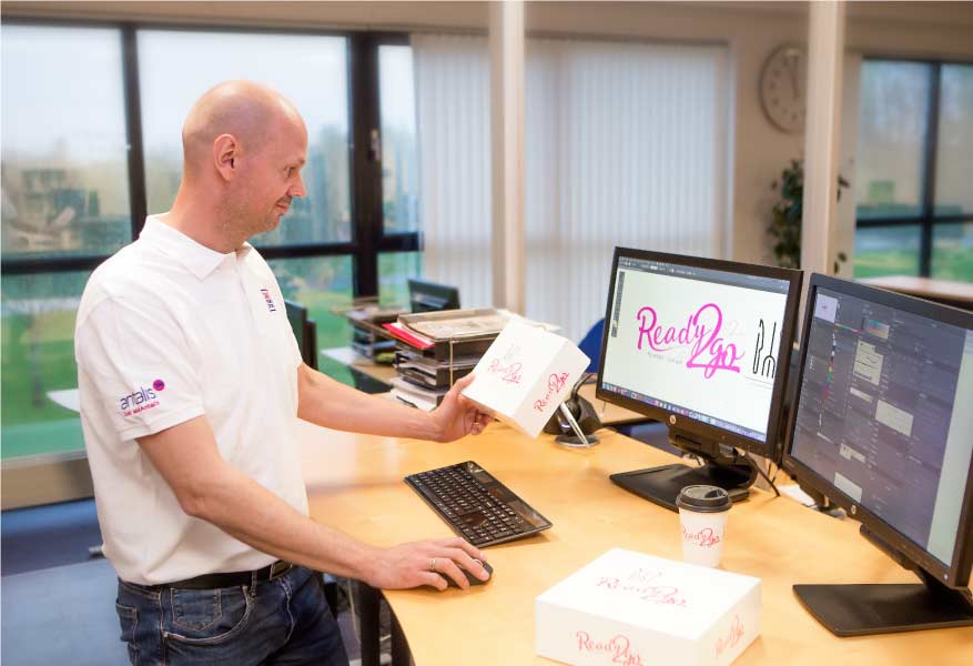 Packaging designer creeert een verpakkings model op zijn computer