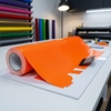 Opvallende bedrijfswagenbelettering met oranje fluorescerende Oracal 6510 folie en carwrap gereedschap in werkplaats
